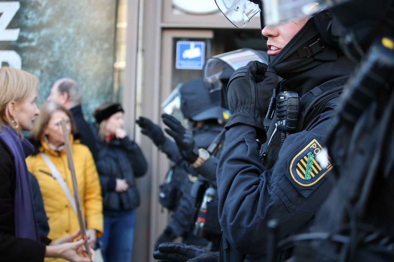 Cops forming a wall in front of a crowd.